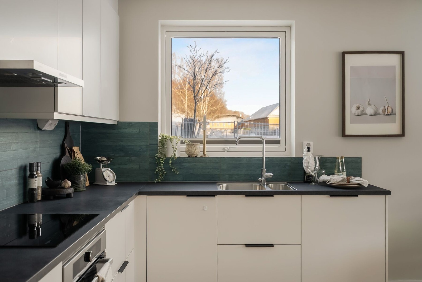 Kjøkkenet byr på integrert induksjonstopp, stekeovn, volumhette, kombi-kjøleskap og oppvaskmaskin. Galleribilde