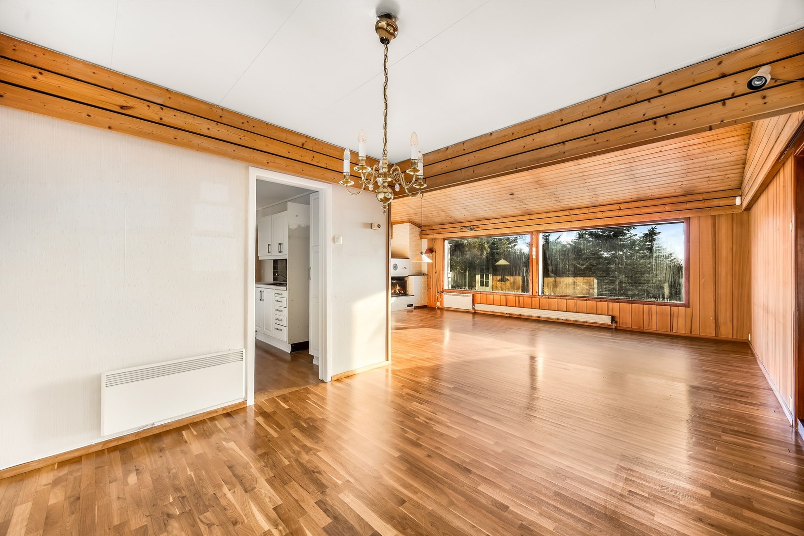 Stuen har god plass til både sitte- og spisegruppe. Inngang til kjøkken. Galleribilde