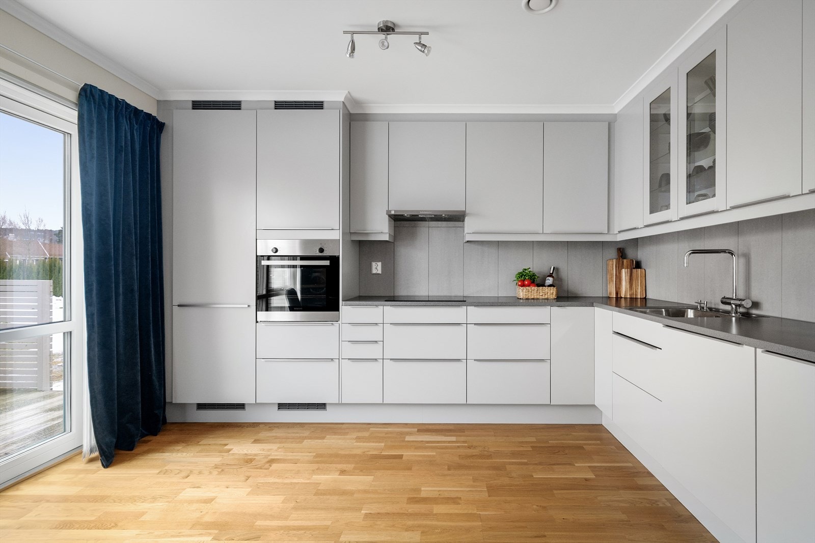 Her er det store vindusflater og verandadør ut til en hyggelig uteplass. Galleribilde