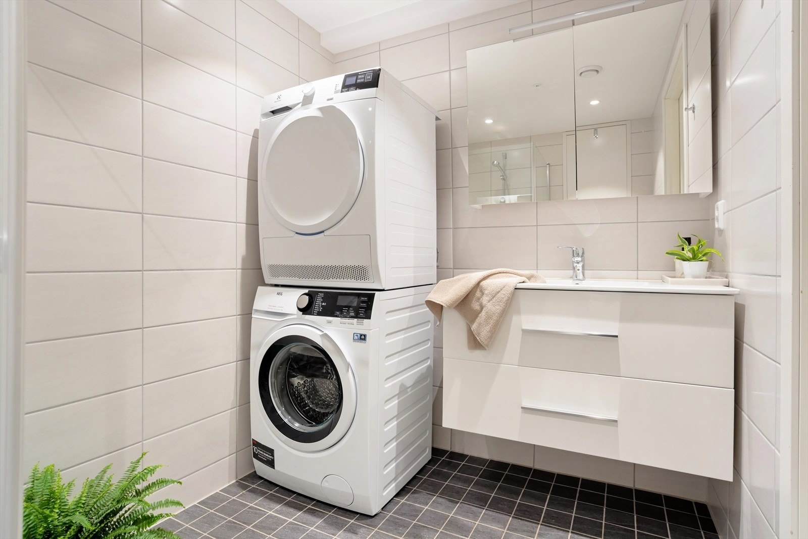 Stilrent baderom med god plass til både vaskemaskin og tørketrommel. Galleribilde