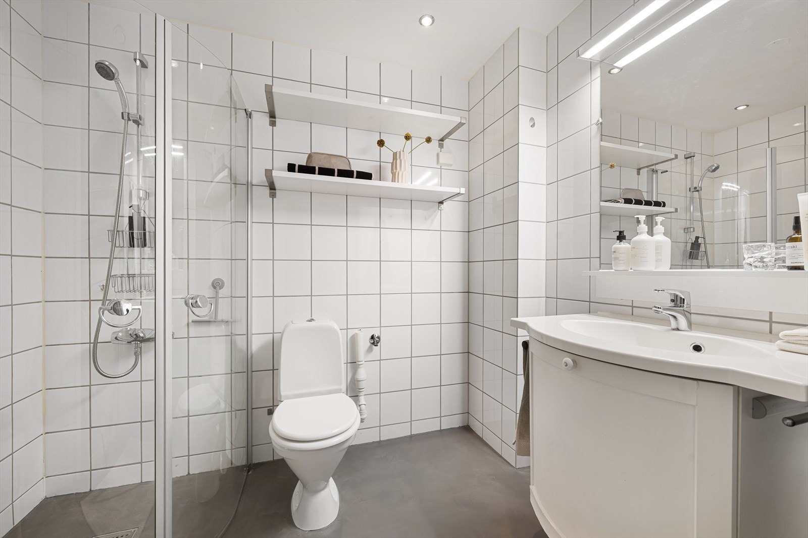 Baderom med flislagte vegger og microsement med varmekabler i gulv Galleribilde