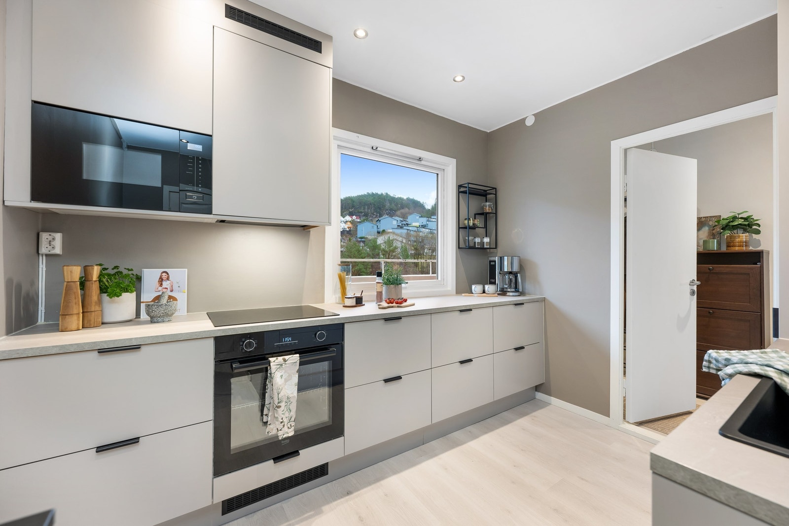 Integrert stekeovn, platetopp, oppvaskmaskin, mikrobølgeovn og kjøleskap med fryser. Hvitevarene medfølger. Galleribilde