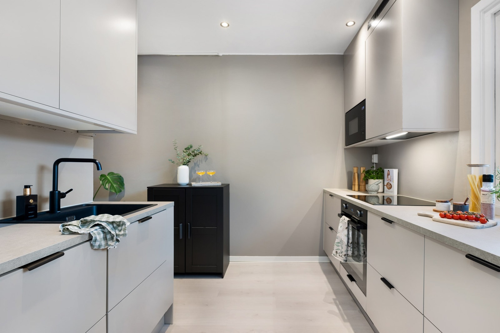 Gjennomført lekkert kjøkken fra Epoq (2023) med glatte fronter og benkeplate av laminat. Ventilator i overskap. Galleribilde