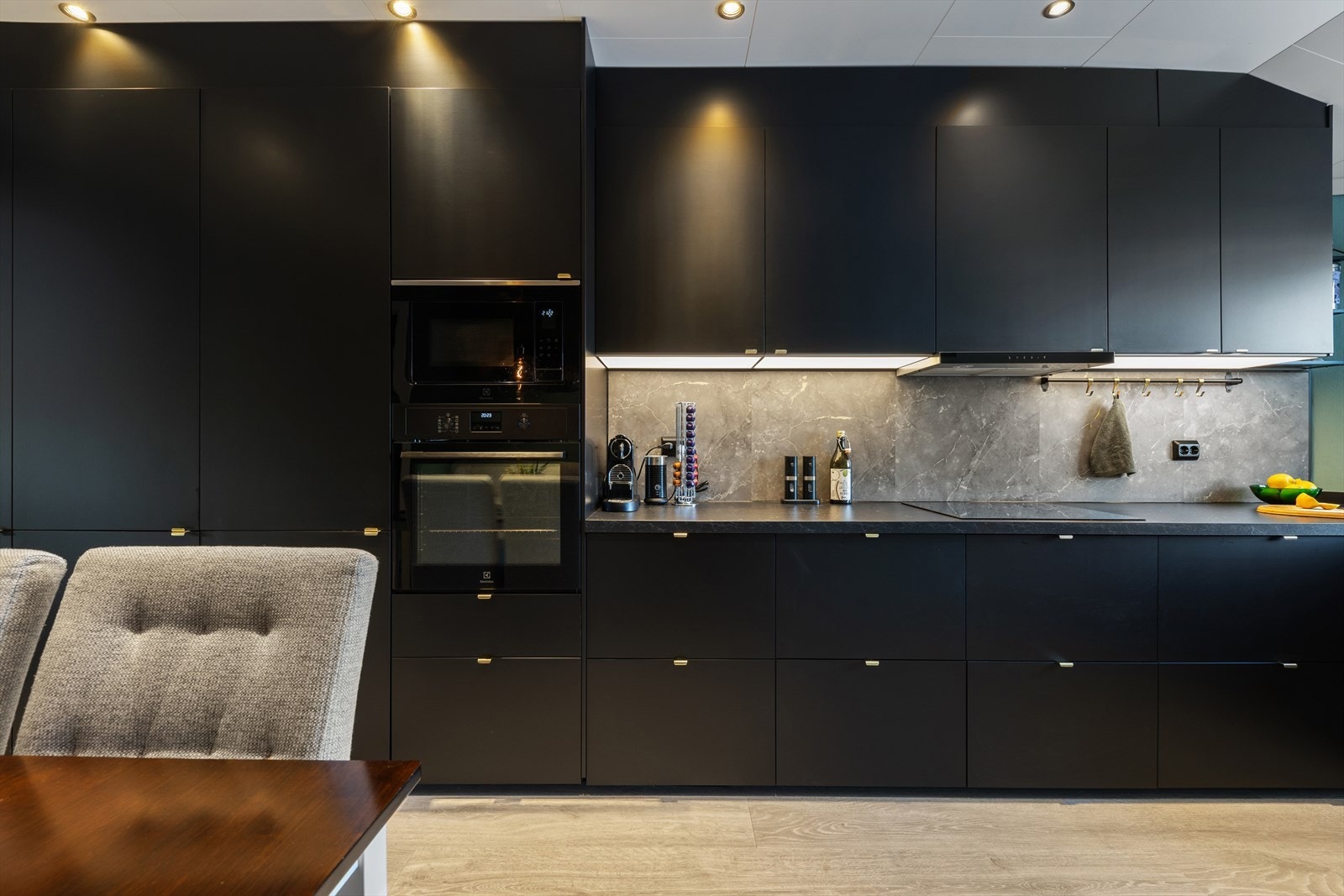 Innredningen er utformet med slette fronter og laminat benkeplate. Det er montert plater mellom kjøkkenbenken og overskapene. Galleribilde