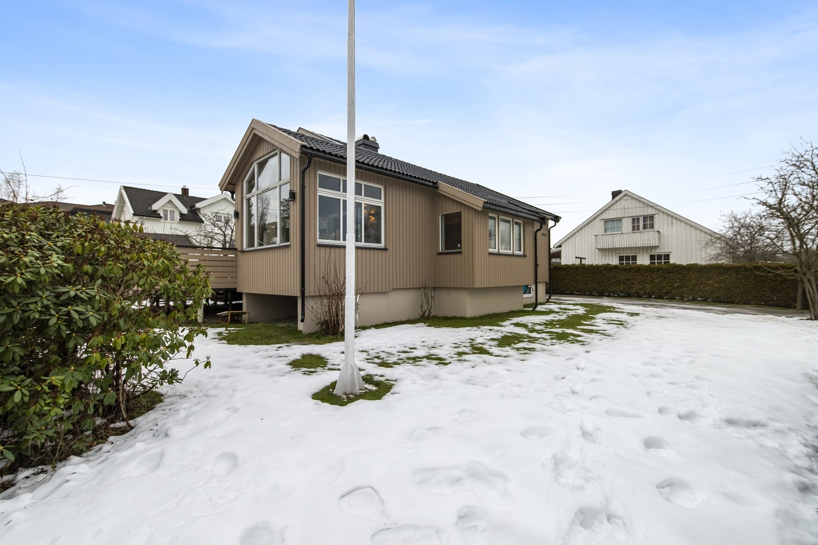 Tomten er pent opparbeidet med flott gressplen, prydbusker og fine blomsterbed. Galleribilde
