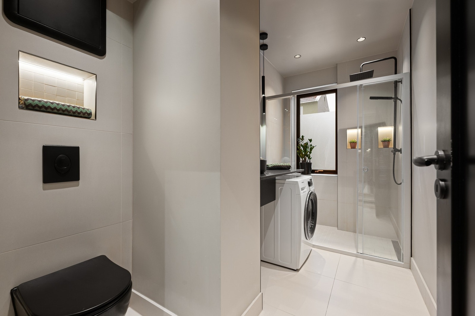 Delikat oppusset bad fra 2022 med gjennomførte løsninger, storformat fliser, gulvvarme og downlights i himling. Galleribilde