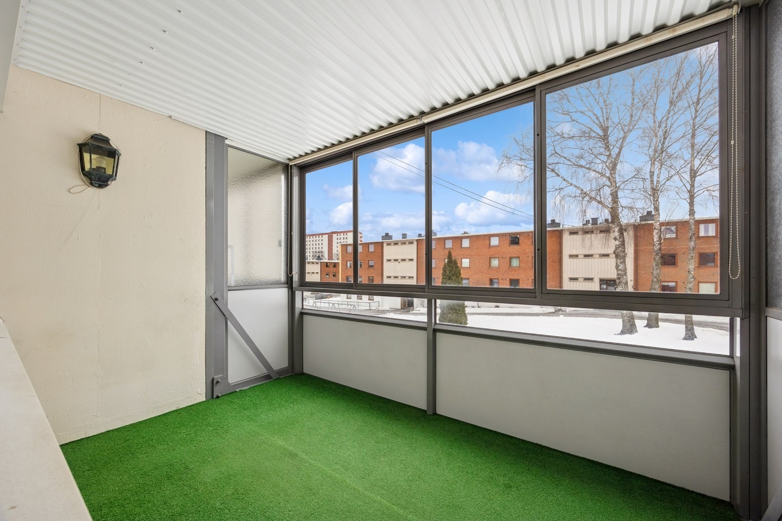 Innglasset balkong på 7 m² gir beskyttet uteplass med utsikt mot nabolaget. Galleribilde