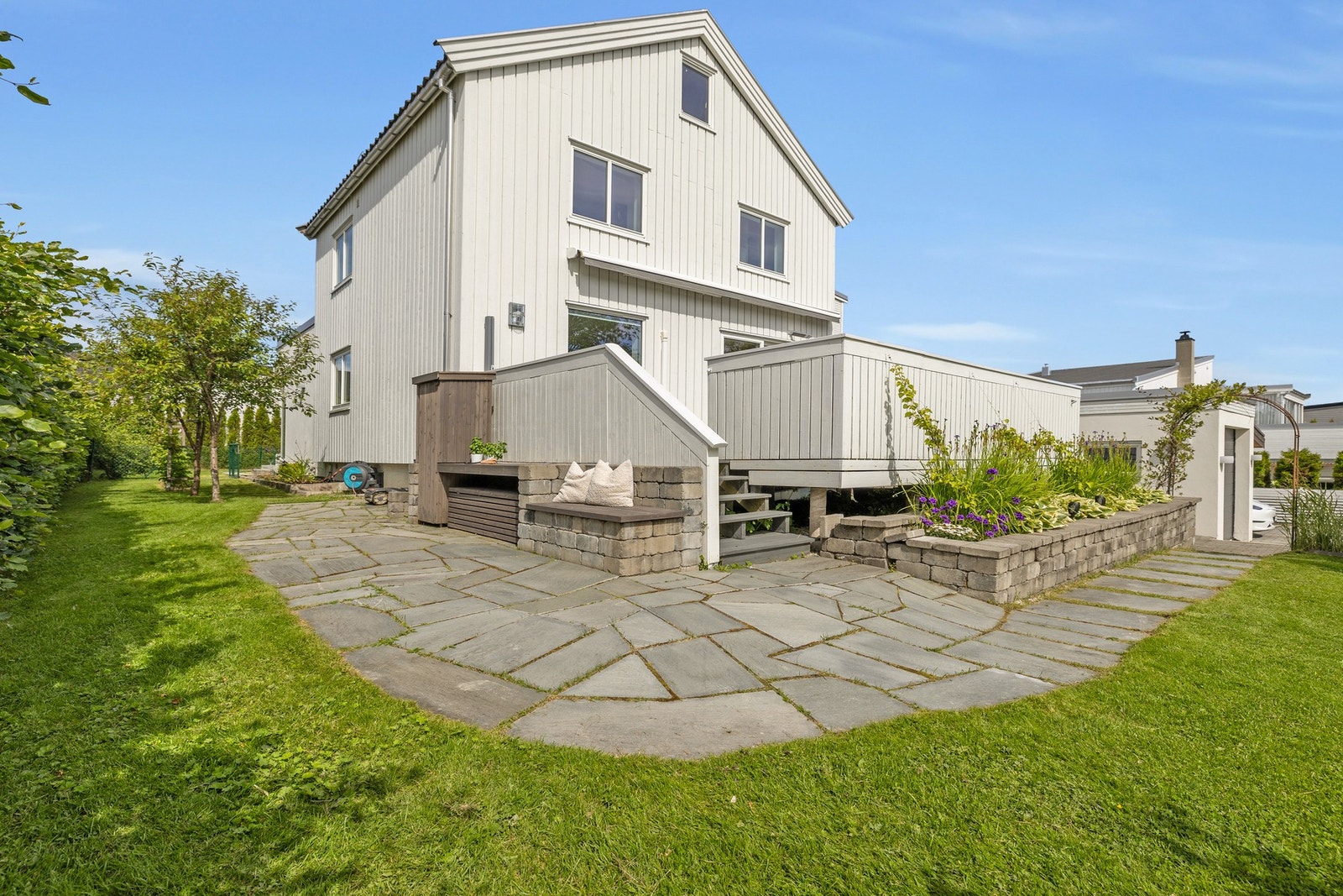 Uteplassen er hellelagt og har koselige sitteplasser og vakker beplantning som bla. bøkhekk (vintertett), frukttrær og bringebærbusker. Galleribilde