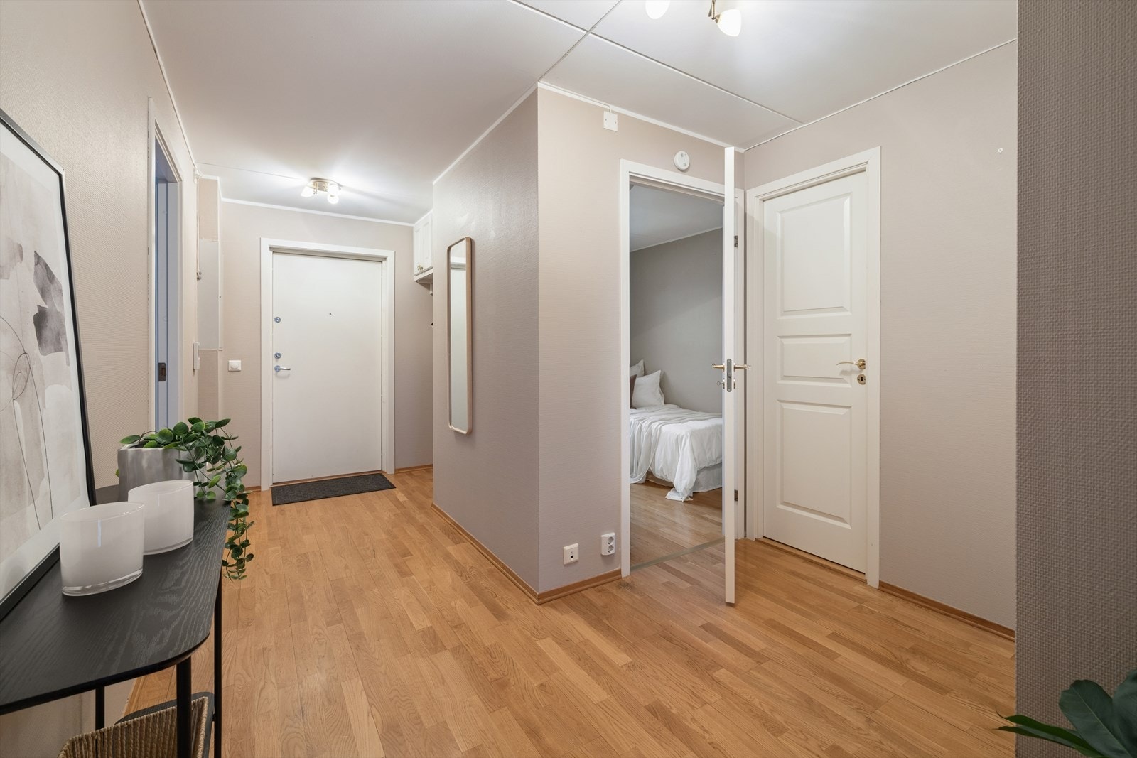 Man ønskes velkommen i en romslig entré med plass til å henge fra seg yttertøy i en garderobenisje. Galleribilde