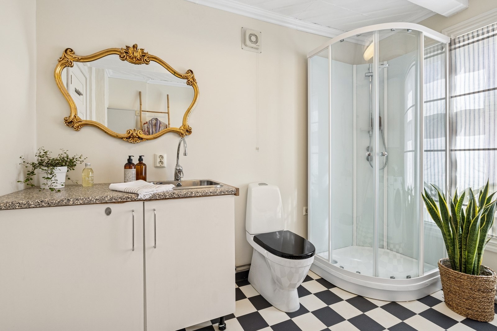 Benkeinnredning, utslagsvask med ett-greps blandebatteri, dusjkabinett, gulvstående toalett og opplegg for vaskemaskin. Galleribilde