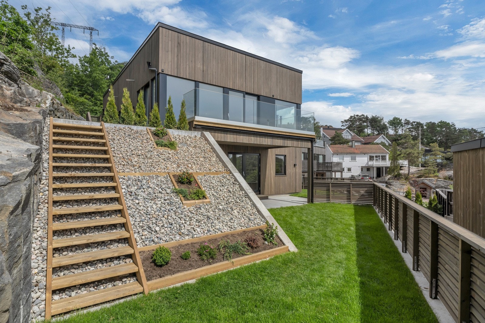 Gressplen på sydøstsiden av boligen - trapp mellom nivåene sikrer enkel adkomst. Galleribilde