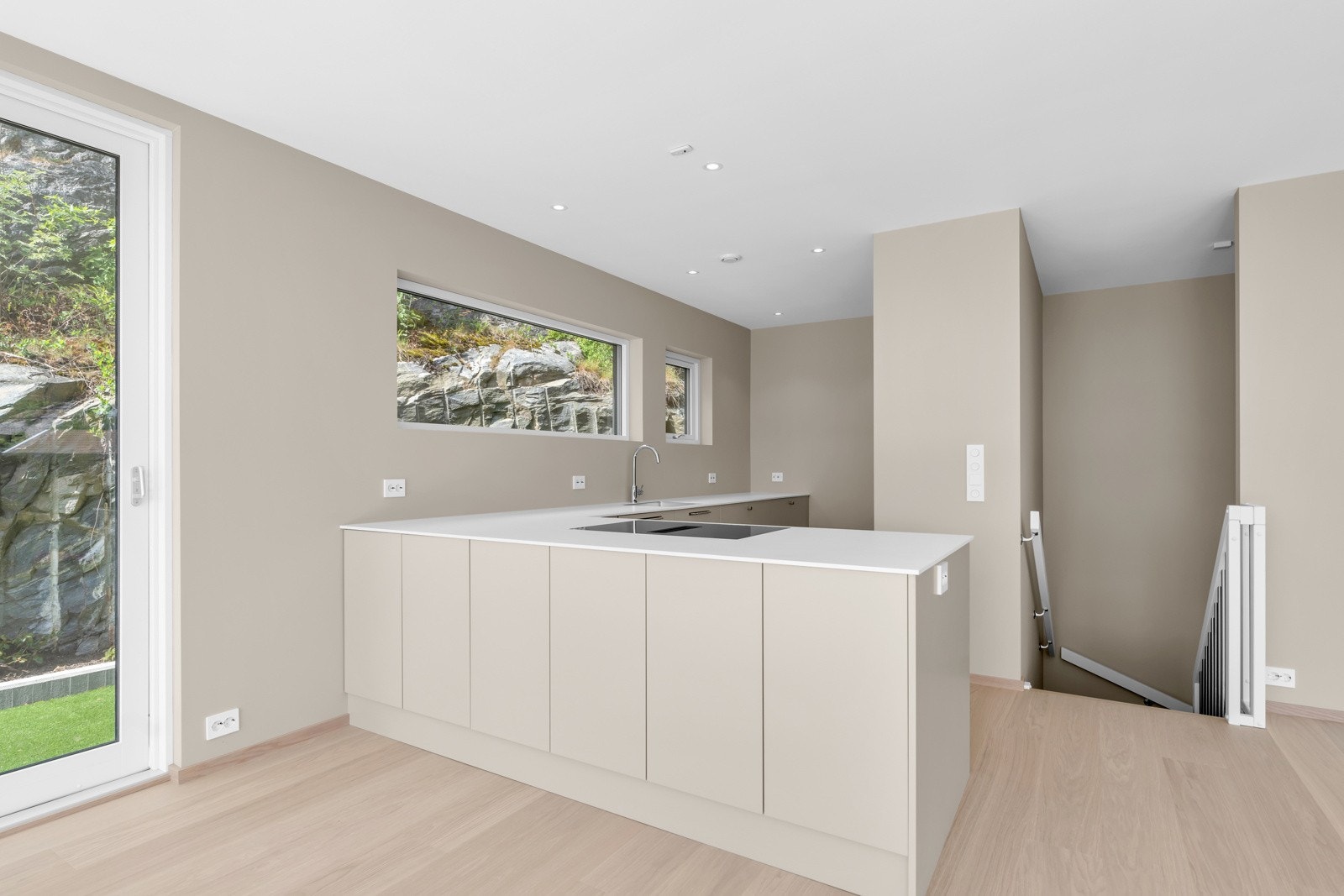 Her får du en gjennomført løsning med rene linjer, integrerte hvitevarer og oppbevaringsmuligheter Galleribilde