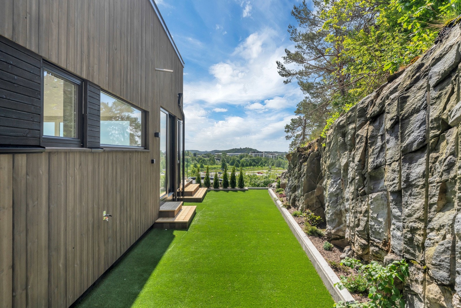 På uteplassen på vestsiden av boligen er lagt kunstgress. Galleribilde