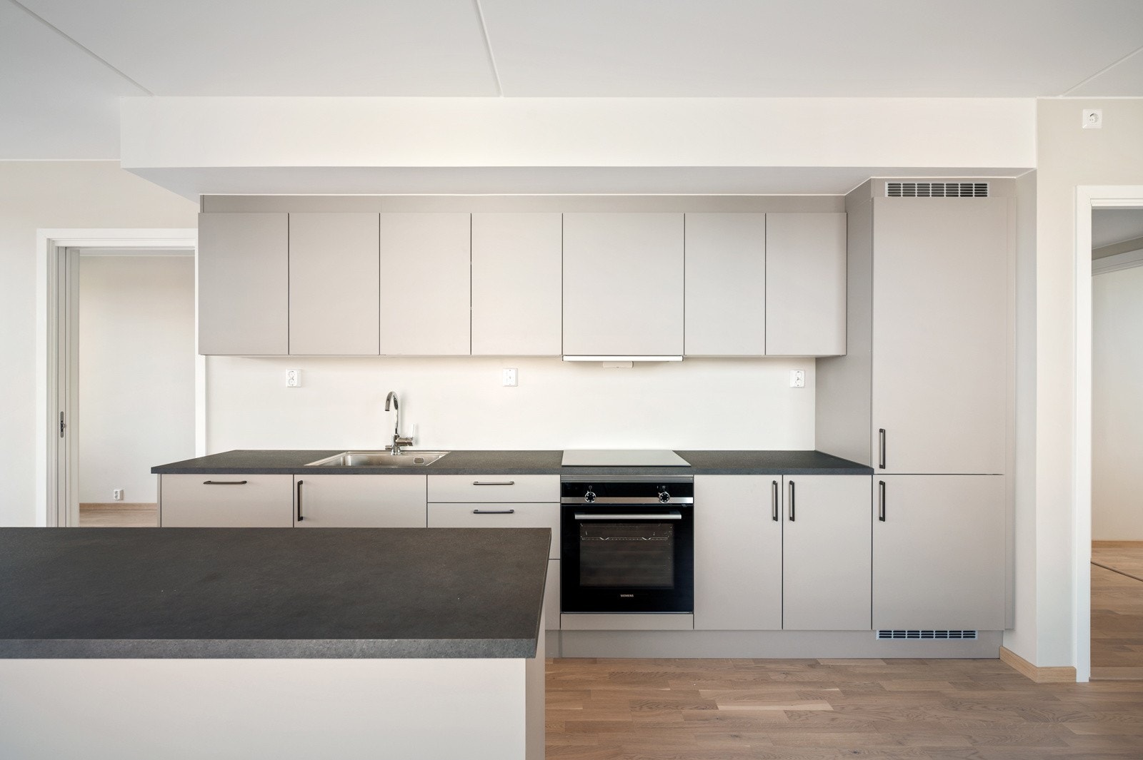 Hvitevarepakken inneholder integrerte hvitevarer som induksjonsovn med platetopp, kjøl/frys og oppvaskmaskin. Galleribilde