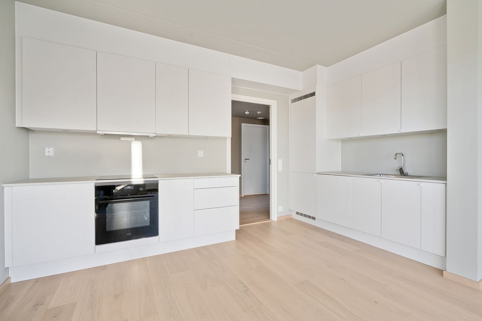 Stilrent kjøkken med integrerte hvitevarer og rikelig skapplass. Galleribilde