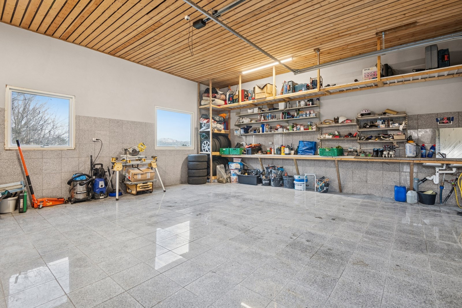 Garasjen har flislagt gulv og samt elektrisk garasjeport. Galleribilde