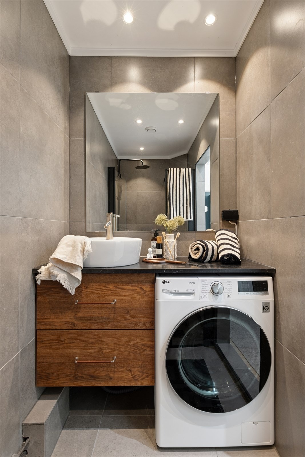 Innredet med servant med innredning, vaskemaskin og benkeplate som gir praktisk funksjonalitet. Galleribilde