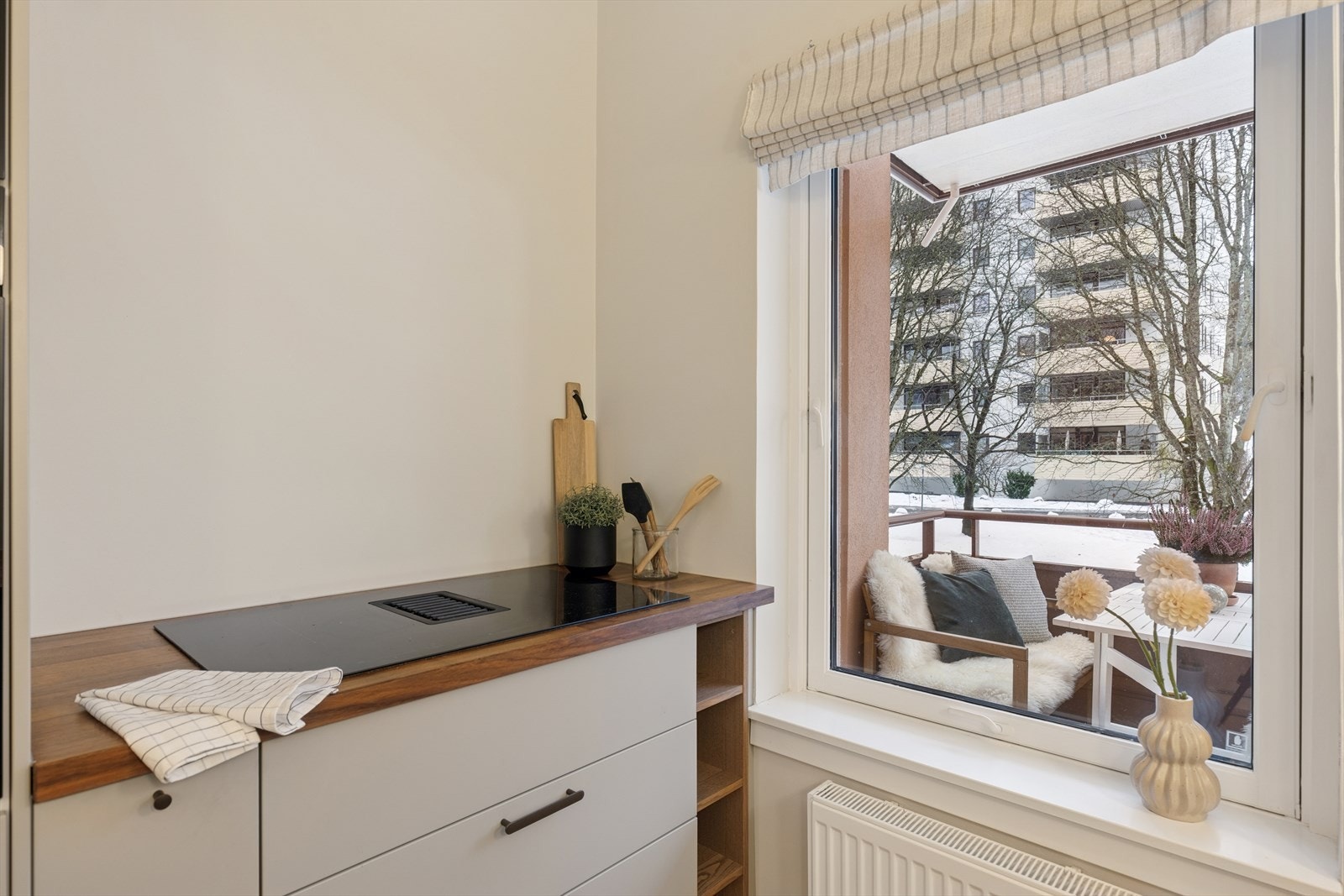 Induksjonstoppen med integrert avtrekk gir en ren og ryddig arbeidsflate, og fra kjøkkenvinduet er det et fint utsyn mot nærområdet. Galleribilde