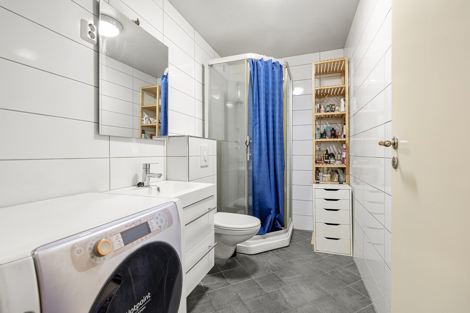 Helflist bad med dusjhjørne og praktisk opplegg for vaskemaskin. Galleribilde