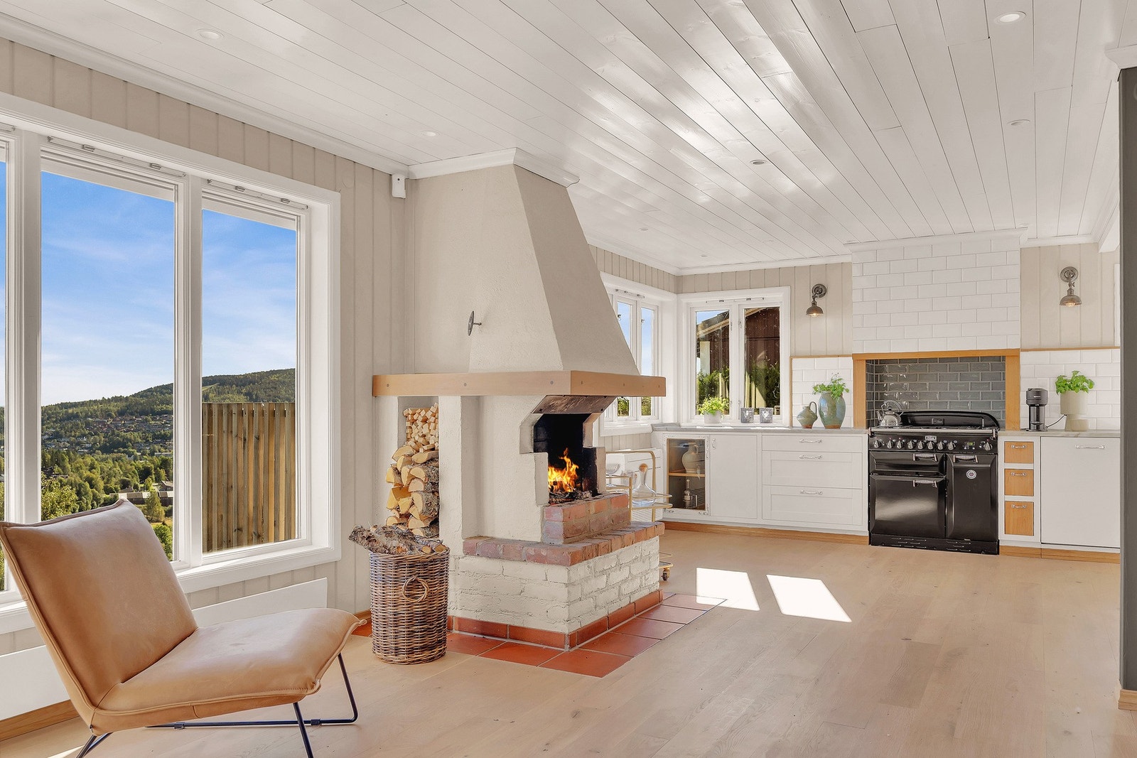 Stor lyst kjøkken med peis og integrerte hvitevarer Galleribilde