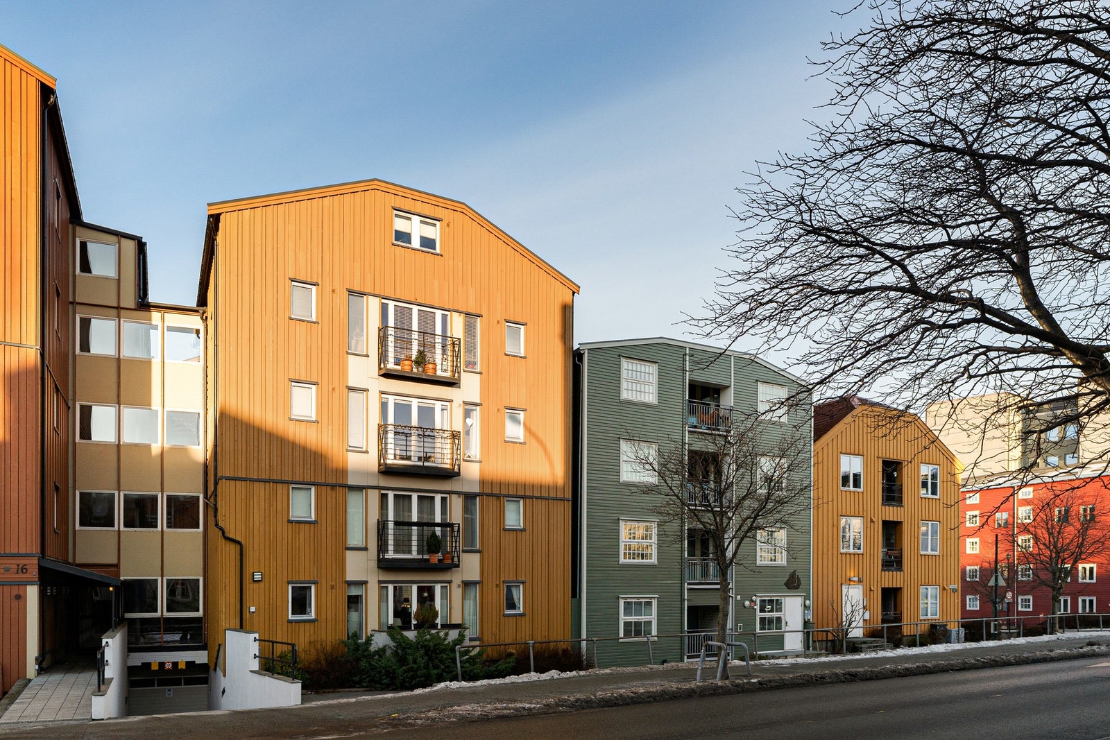Innkjøring til felles parkeringskjeller. Leiligheten har en liten balkong på framsiden. Galleribilde