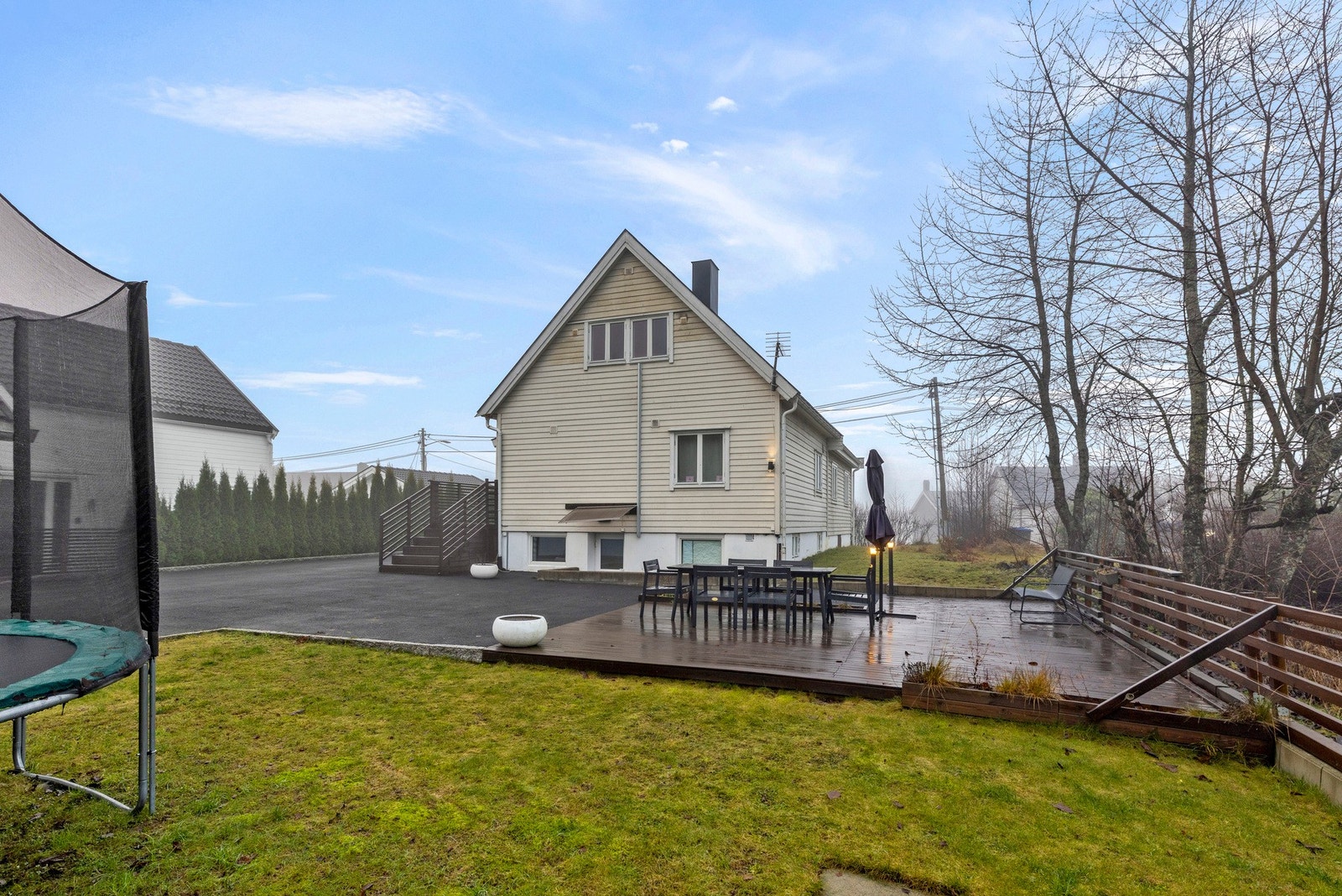 Pent opparbeidet tomt med gressplen, platting og asfaltert vei. Galleribilde