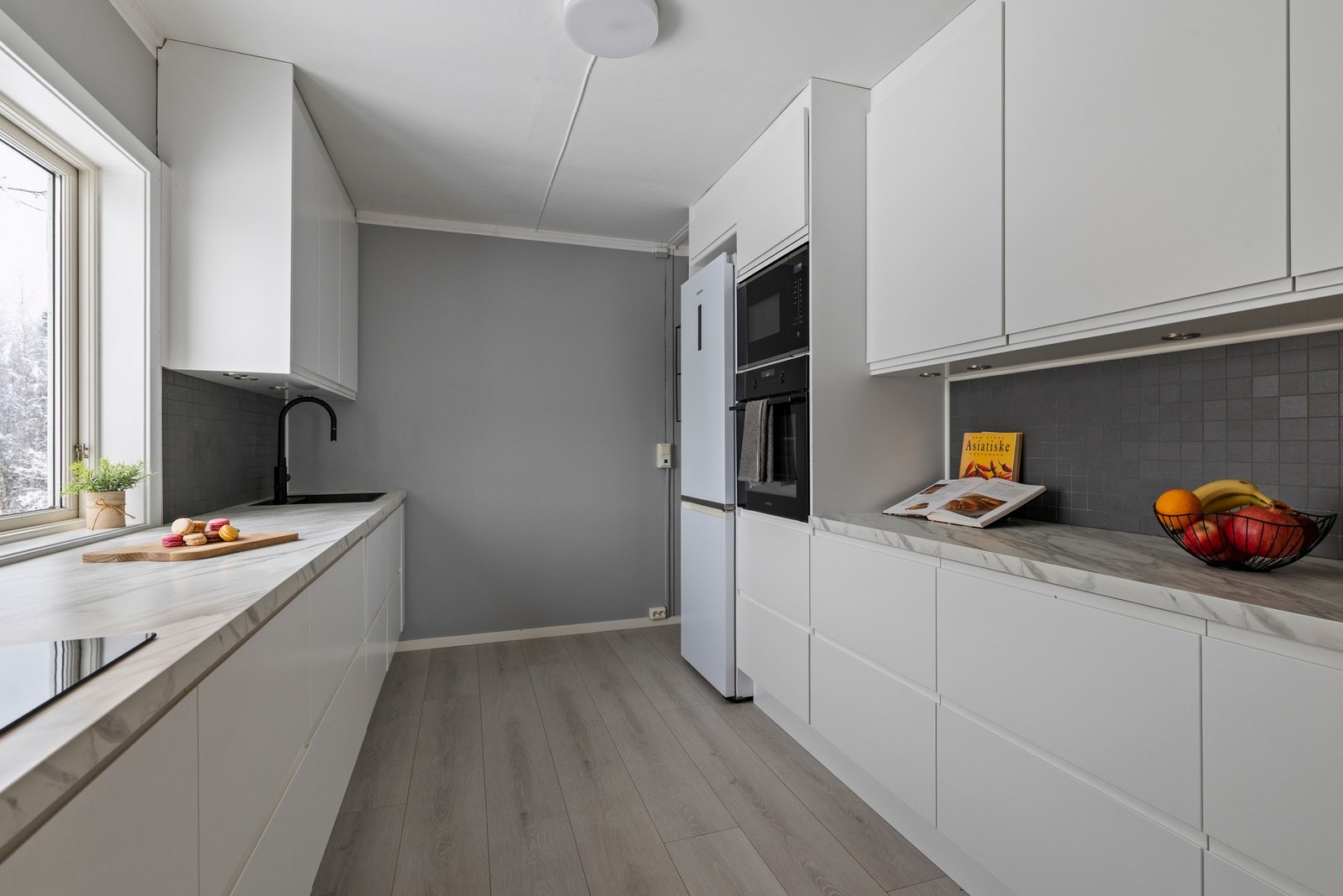 Kjøkkenet har et sømløst uttrykk med integrert oppvaskmaskin, mikro, stekeovn og induksjon platetopp. Galleribilde