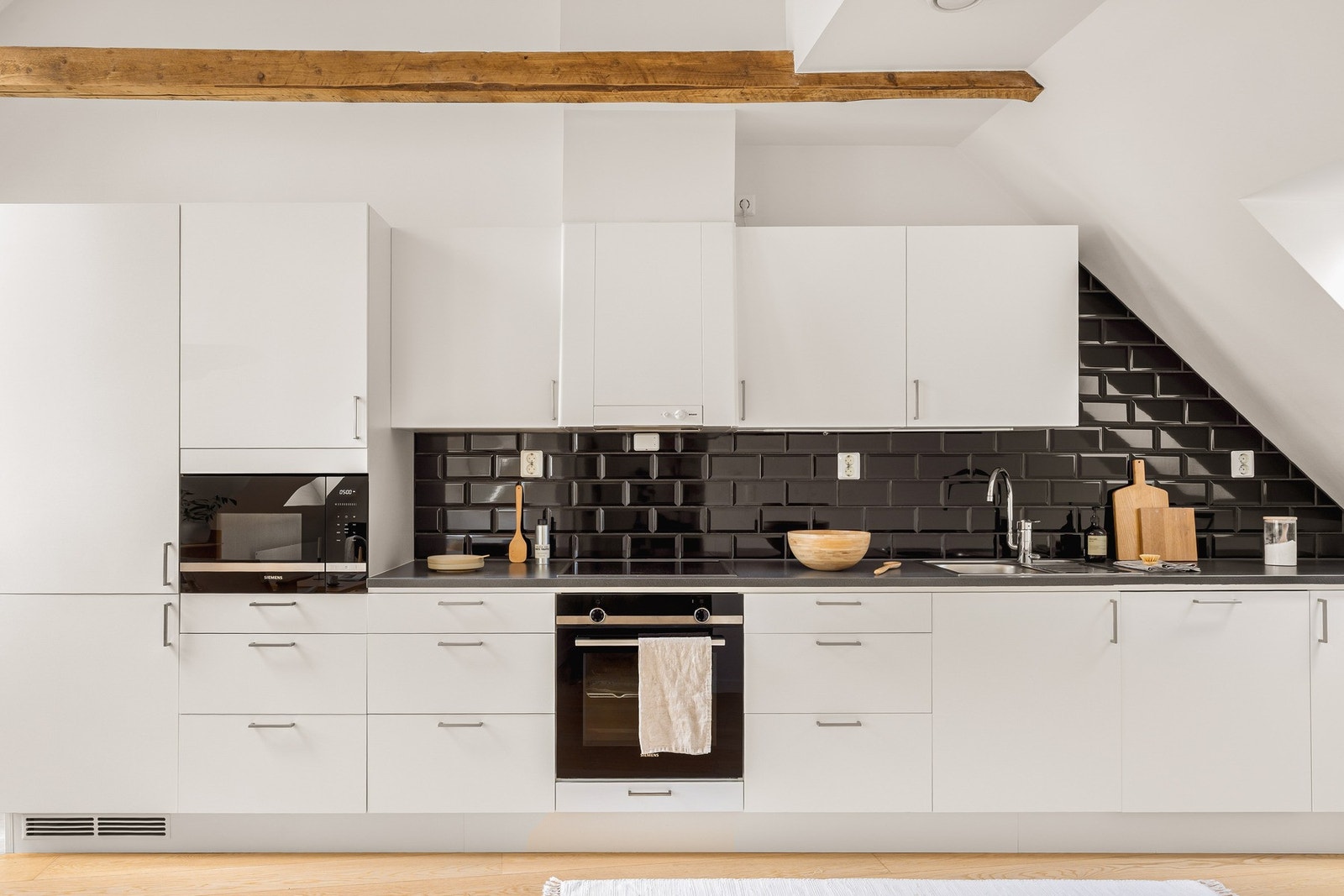 Kjøkkeninnredning med slette fronter og laminat benkeplate med nedfelt vask av stål. Galleribilde