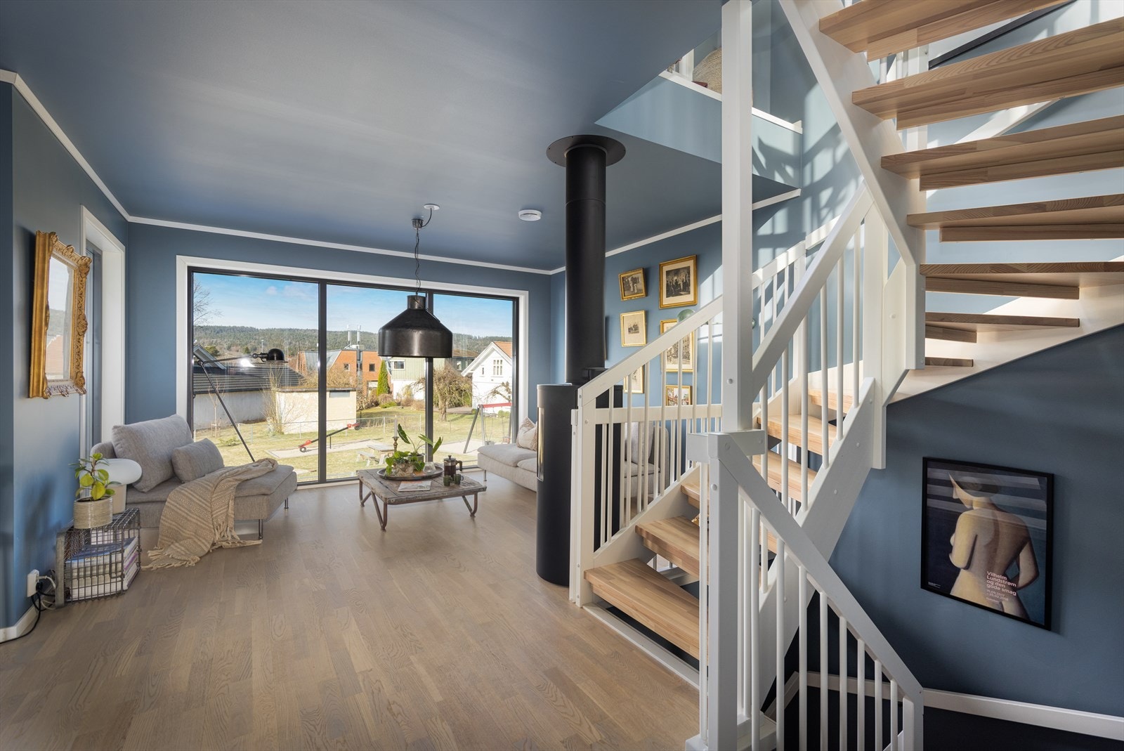 Velkommen opp i 2. etasje! Her møtes du av en lys og trivelig stue med store vindusflater som slipper inn rikelig med dagslys. Både vegger og himling er malt i behagelige farger som skaper en lun og innbydende atmosfære. Galleribilde