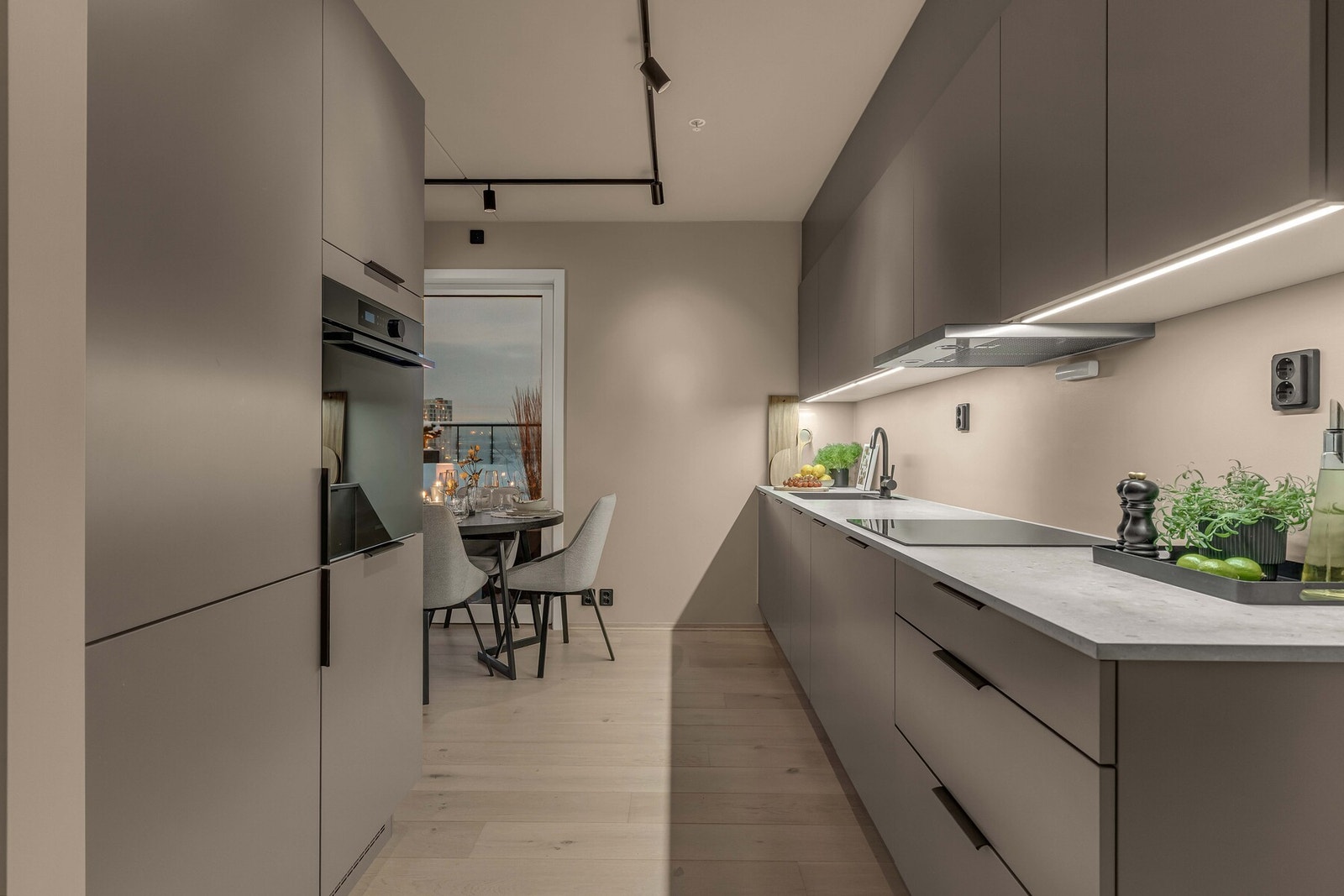 Innredningen har glatte fronter i en dempet brunbeige tone. (HTH Leire), kombinert med benkeplate i laminat og underlimt kum i sort kompositt. Galleribilde