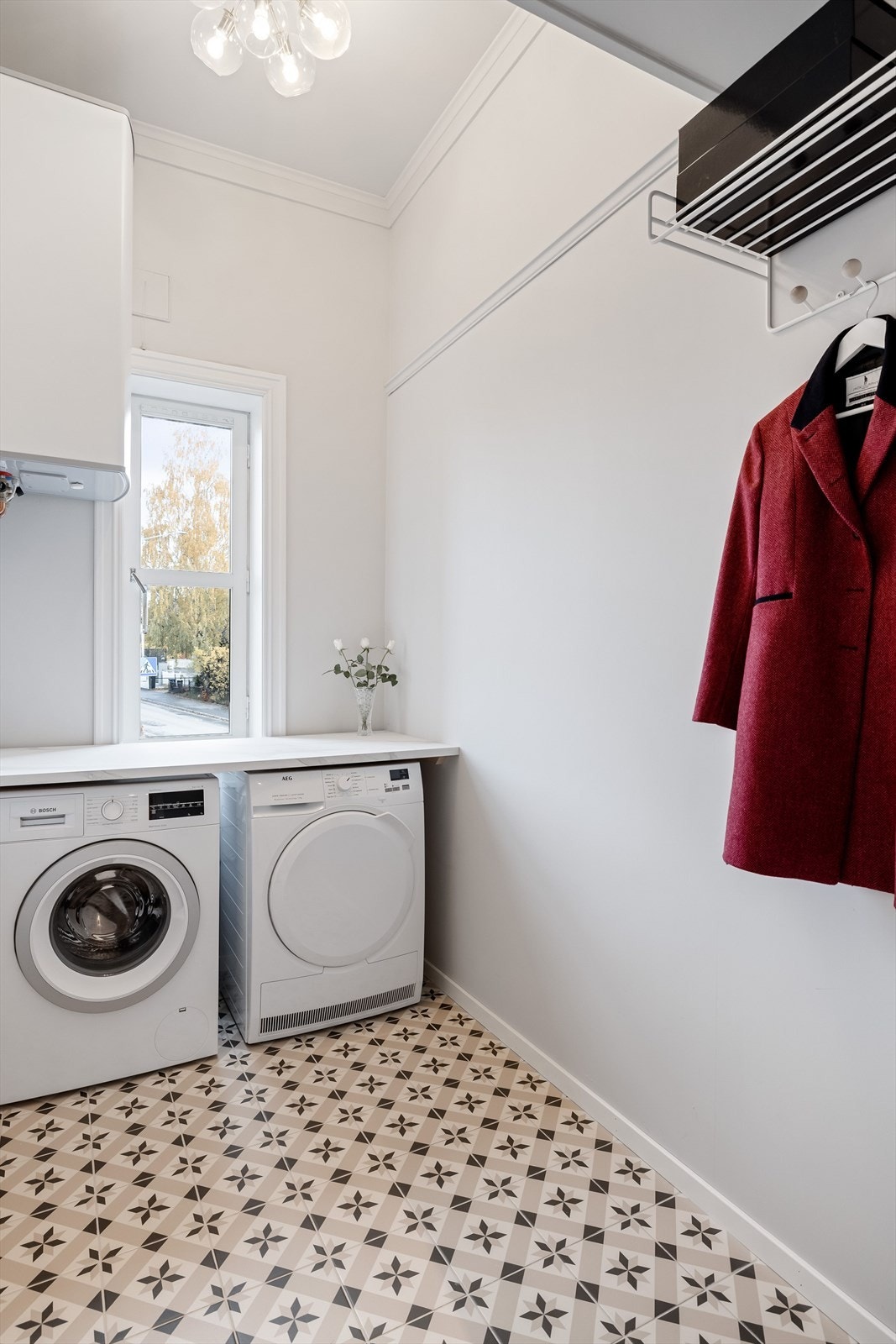 I tillegg har leiligheten et praktisk vaskerom med flislagt gulv. Her er det benkeplate med plass til vaskemaskin og tørketrommel under. Det er også rom for å sette inn garderobeskap om det er behov for det. Galleribilde