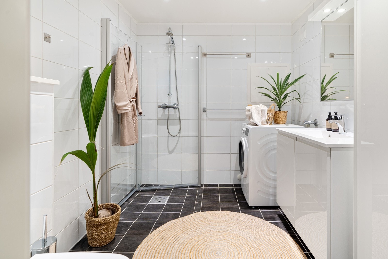 Det flislagte badet er praktisk innredet med dusjhjørne, servant og toalett. Galleribilde