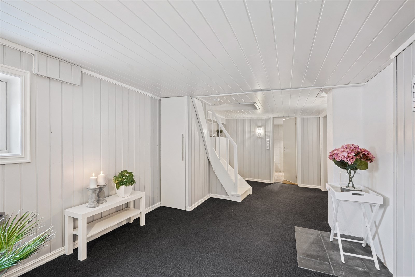 Fra trappene kommer du ned til et trapperom/mellomgang med muligheter for oppbevaring. Galleribilde