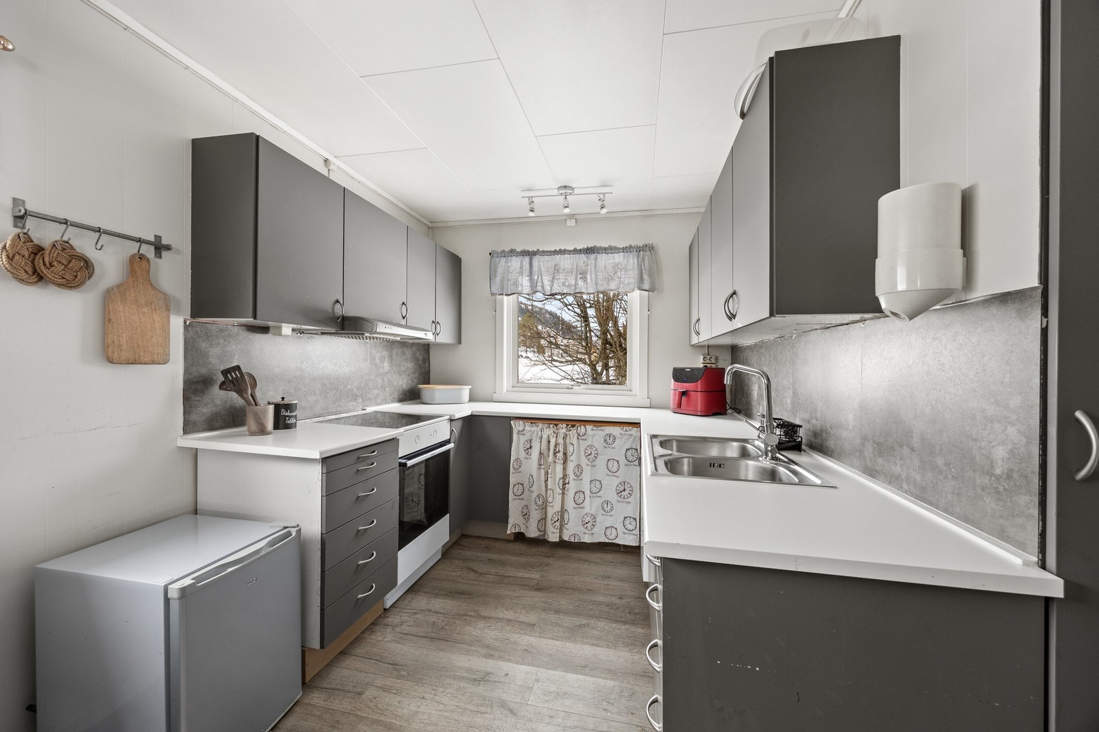 Kjøkkeninnredning med avsatt plass for hvitevarer og opplegg for oppvaskmaskin Galleribilde