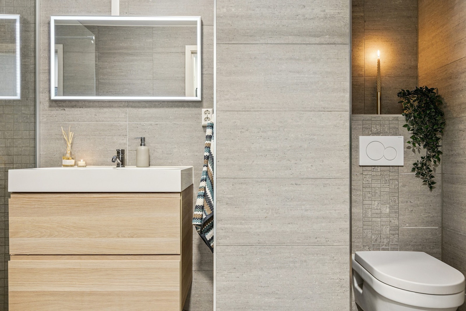 Badet er på 4,9 kvm og er innredet med vegghengt servantinnredning, servant, speil med overlys, dusjnisje og vegghengt toalett. Galleribilde