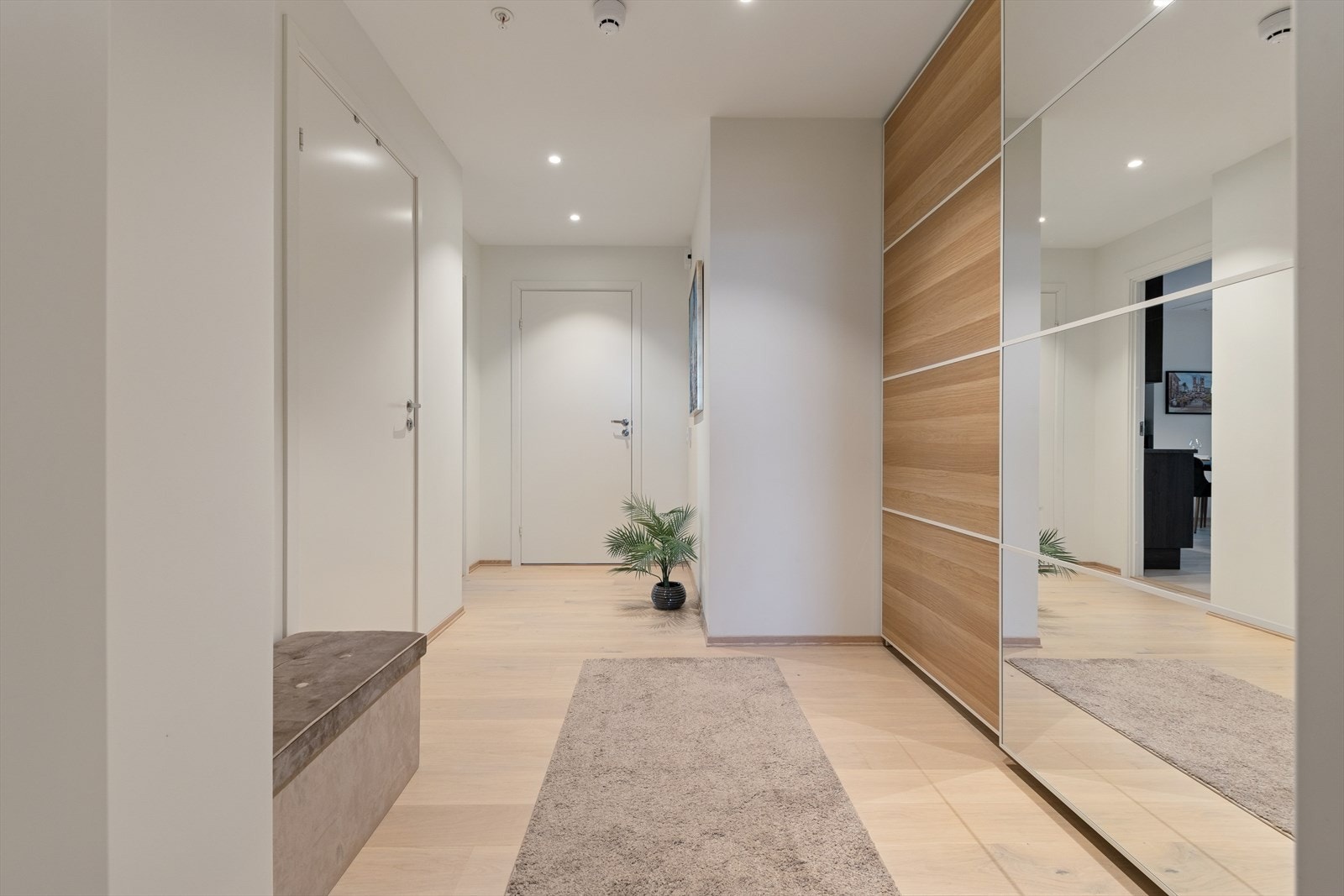 Lys og romslig entré med parkett på gulvet og downlighets i taket. Galleribilde