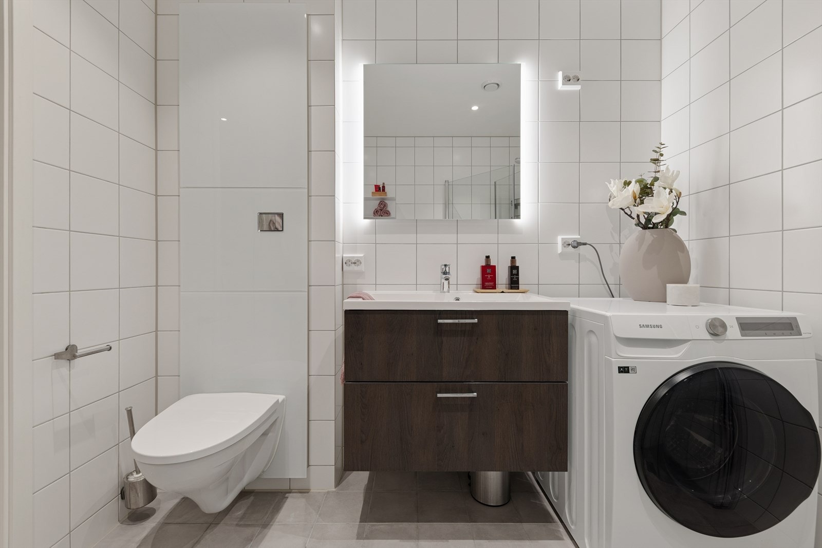 Innredningen består av speil, nedfelt servant, veggmontert toalett og dusjhjørne. Galleribilde