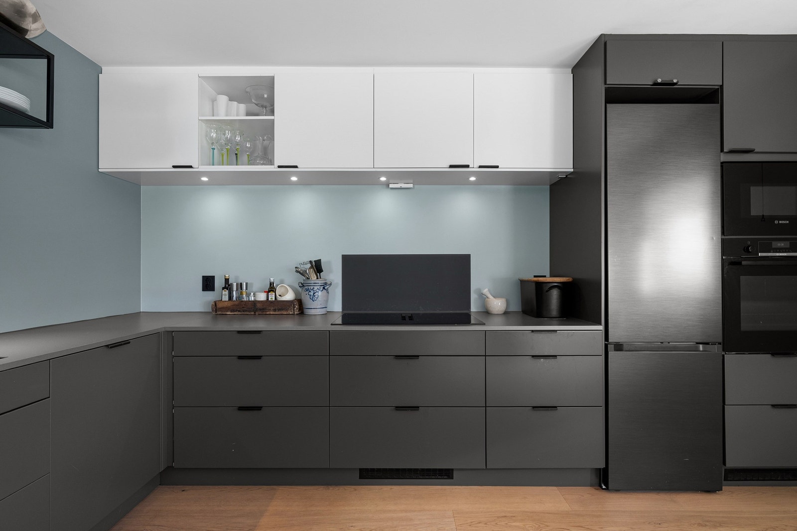 Kjøkkenet er utstyrt med integrerte hvitevarer som stekeovn, mikrobølgeovn, oppvaskmaskin, vinskap og platetopp med integrert ventilator. Frittstående kjøleskap i nisje Galleribilde