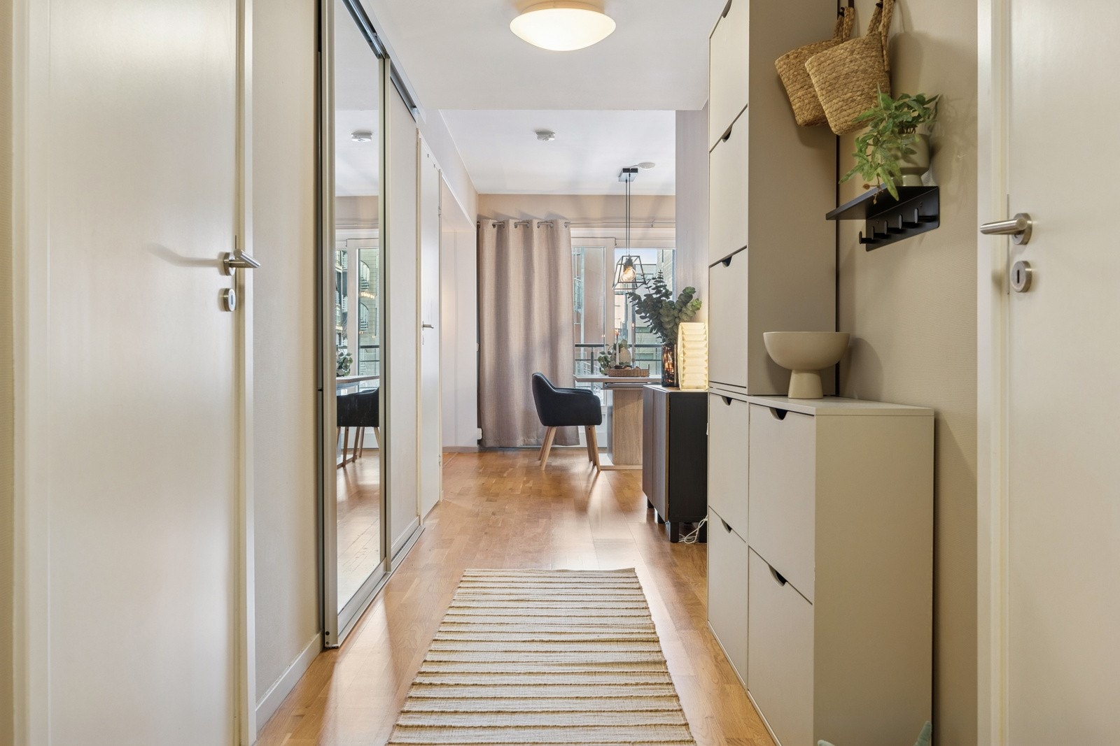 I gangarealet er det etablert en stor skyvedørsgarderobe - en stilren og praktisk løsning som gir rikelig med plass til yttertøy og sko, samtidig som den holder gangarealet ryddig og oversiktlig. Galleribilde