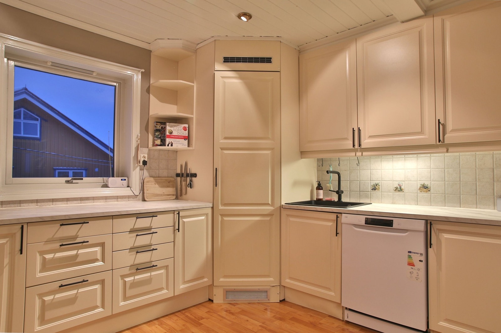 Kjøkken med mye oppbevaringsplass og stort kjølehjørne Galleribilde