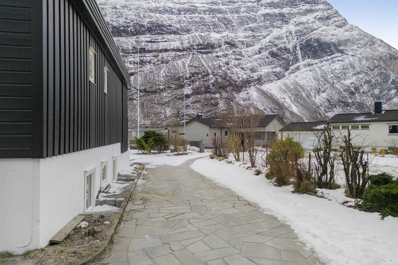 Boligen har en steinlagt gangvei som gir enkel tilgang fra gate til inngangspartiet. Galleribilde