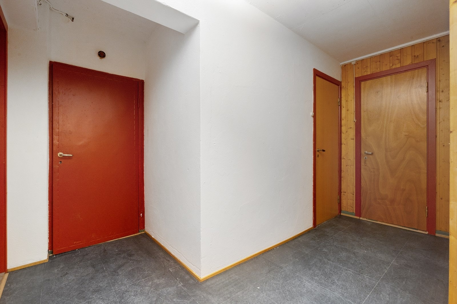 Den røde døren gir tilgang til teknisk rom, de to andre går til kjellerstue og en liten bod. Galleribilde