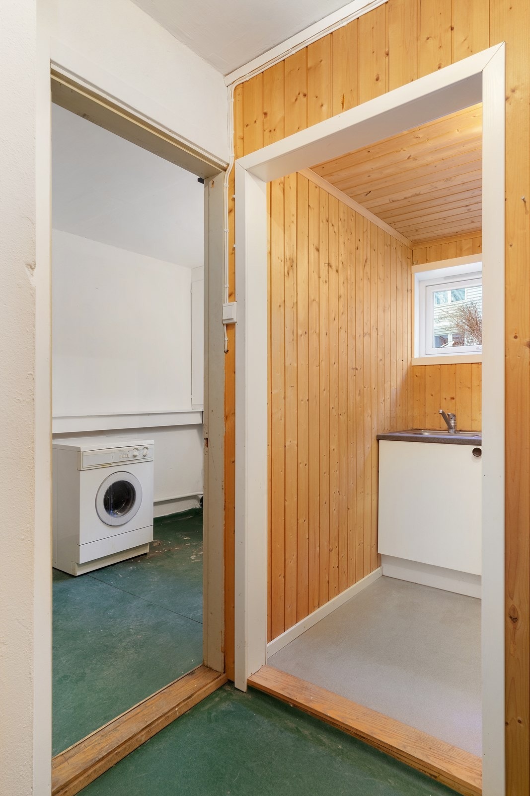 Ved siden av trappen som fører ut finner man en mellomgang som fører til et lite kjøkken og vaskerom med dusj. Galleribilde