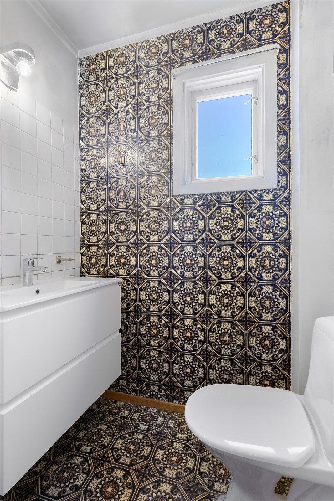 Toalettrom med gulvmontert wc og servant med underskap. Galleribilde