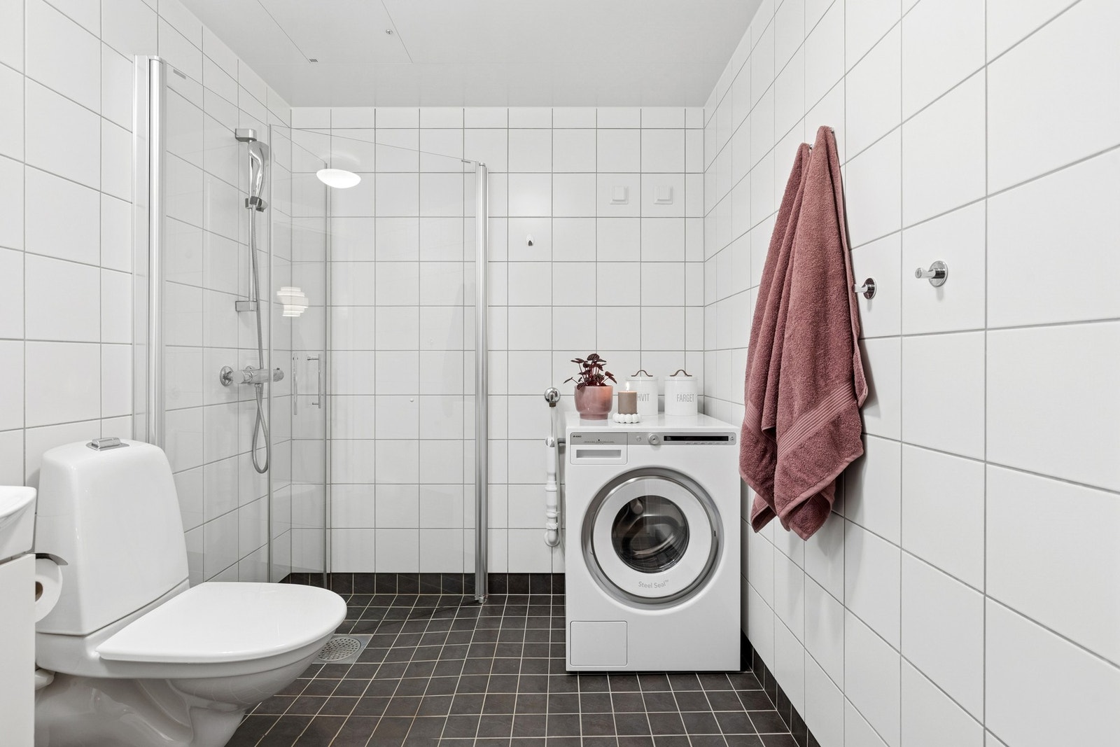 Baderommet fremstår som moderne og funksjonelt og byr på flislagte gulv og vegger med varme i gulv som gir god komfort. Galleribilde