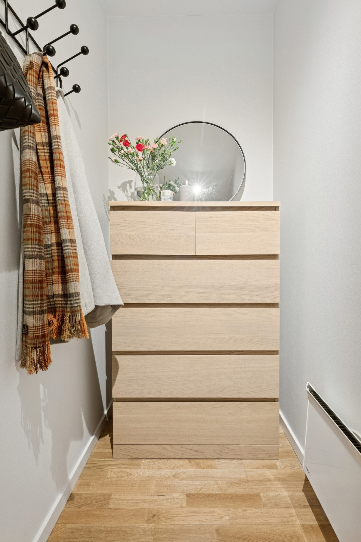 Entréen fremstår som lys og innbydende med parkett på gulv og malte overflater på vegger og himling. Her er det god plass til yttertøy og sko, og løsningen gir en praktisk og ryddig adkomst til boligens øvrige rom. Parkettgulvet videreføres gjennom store Galleribilde