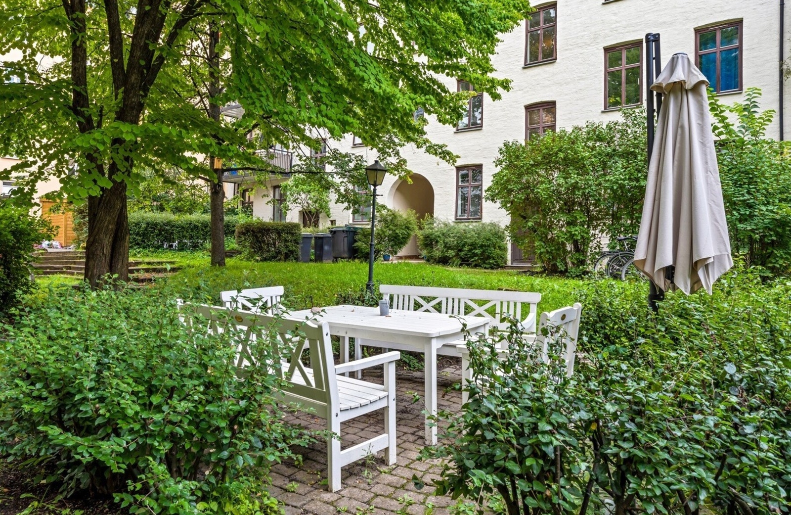 Indre gårdsrom er pent opparbeidet med frodig beplantning og steinbelagte områder. Galleribilde