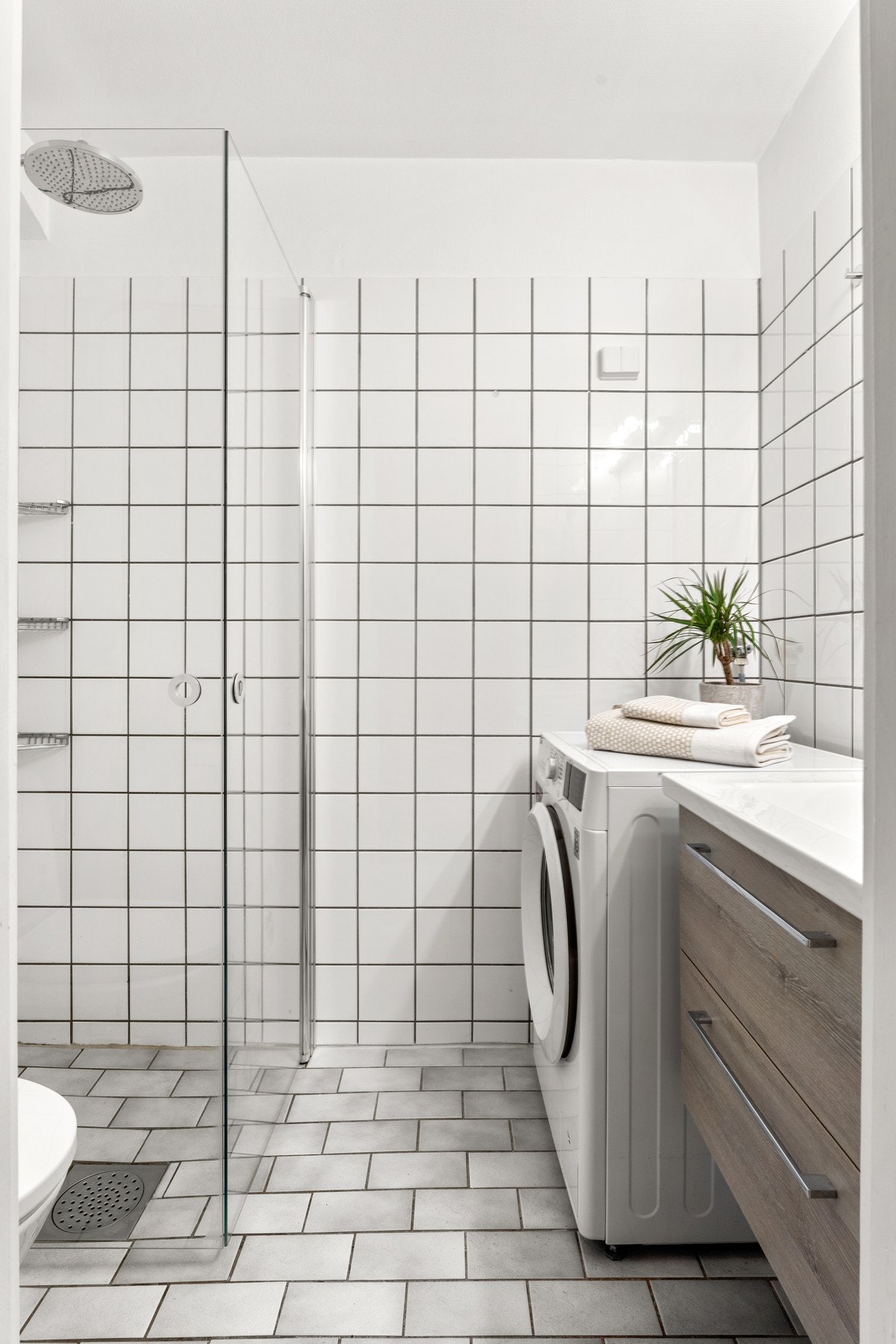 Badet har adkomst fra gangen og er innredet med toalett, varmekabler og opplegg for vaskemaskin. Galleribilde