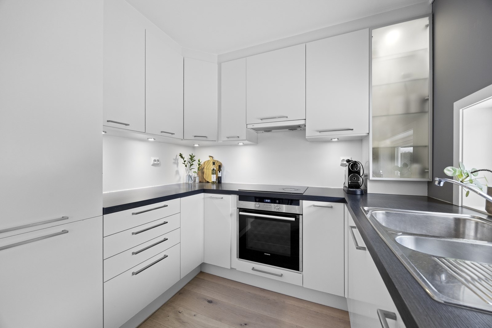 Effektiv kjøkkenløsning med integrert stekeovn og induksjonstopp, samt kjøle- og fryseskap. Galleribilde