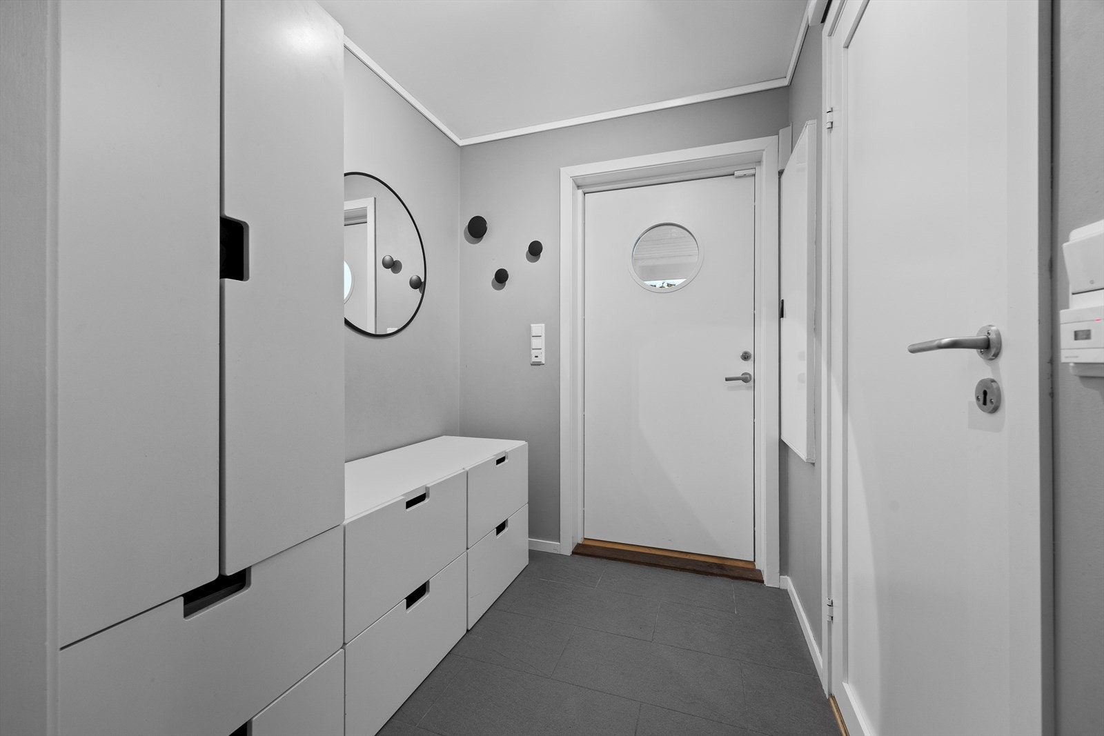 Flislagt gulv gir en praktisk entré, og det er plass til effektiv oppbevaring med skapløsninger. Ved siden av gangen er det vaskerom med toalett og vask. Galleribilde